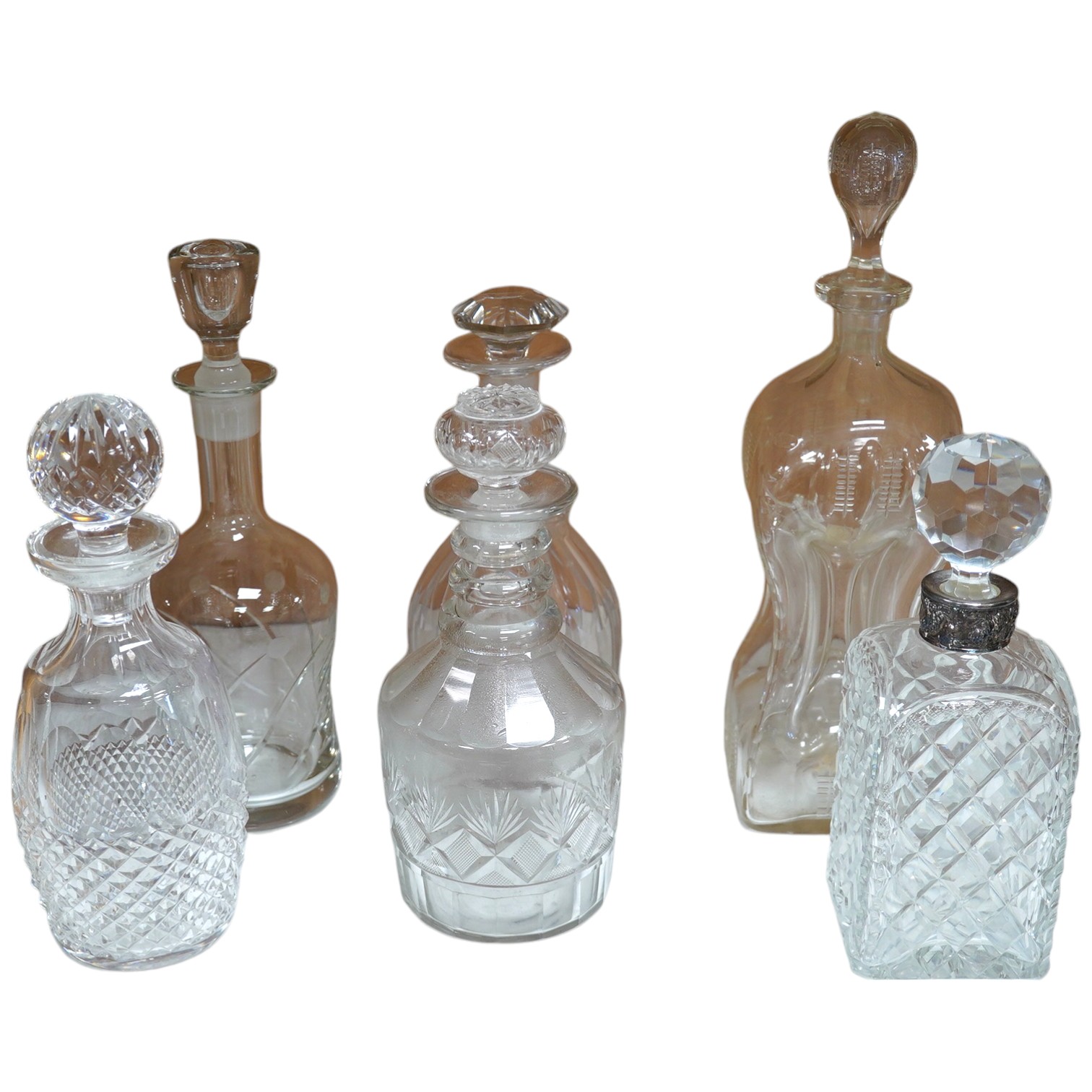 Six 19th century and later cut glass decanters and stoppers, one with white metal acorn design collar, largest 37cm high. Condition - fair, some chipping / impact damage